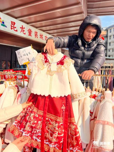 老王正在给围在摊位前的家长们推荐款式。记者 邹宸 摄