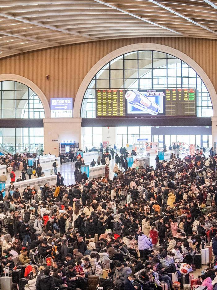 在武汉汉口火车站内,人潮涌动,大批旅客携带行李踏上归家旅途