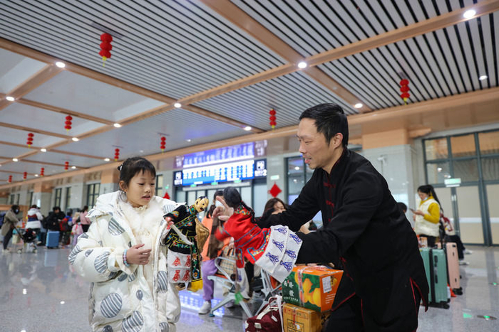 2024年1月26日，布袋木偶戏表演人员在福厦高铁泉州南站候车室与小朋友互动。新华社记者 周义 摄