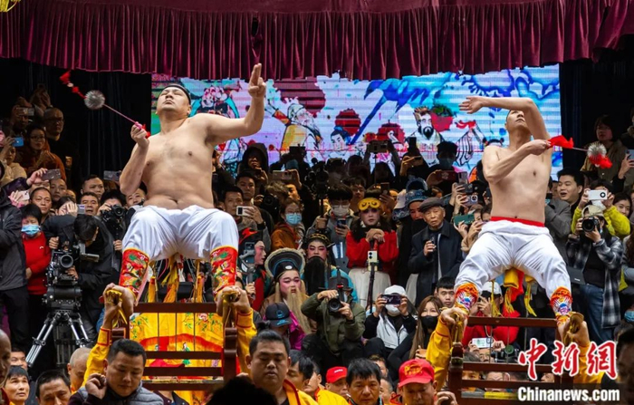 赤身赤脚的村民稳坐在用钢刀做成的“刀轿”上，不时用直径10厘米的铁球甩打脊背。中新社记者 王东明 摄