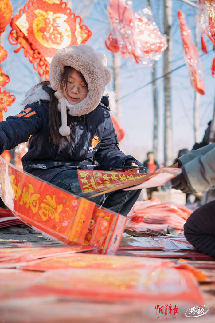 北京沙河大集，一个年轻人正在挑选春联。 中青在线记者 白杨/摄