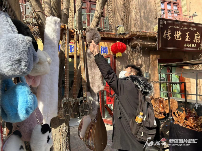 1与27日，游客正在喀什古城选购春节礼品。石榴云/新疆日报记者 阿比拜摄
