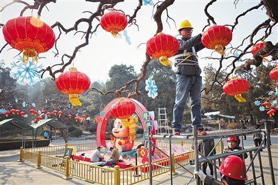 1月29日，景山公园，工作人员正在挂红灯笼，在他身后，市属公园龙年生肖IP形象“隆隆”亮相。新京报记者 薛珺 摄