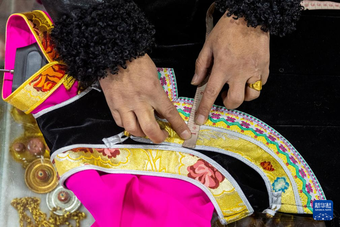 尼玛王登在店里根据客户定制藏装的需求进行设计（1月4日摄）。新华社记者沈伯韩摄