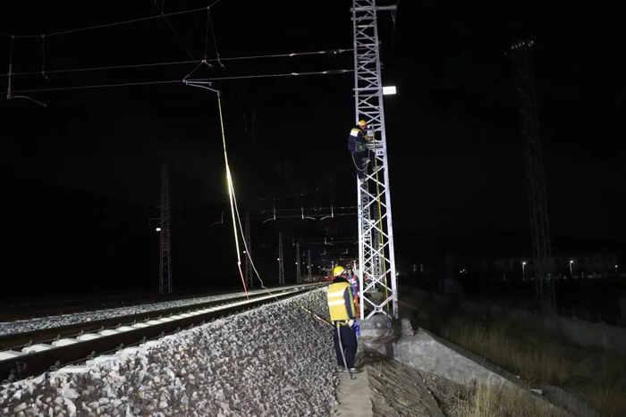 拉萨南接触网维修队工作人员为接触网接挂地线.新华社发(拉巴次仁 摄)