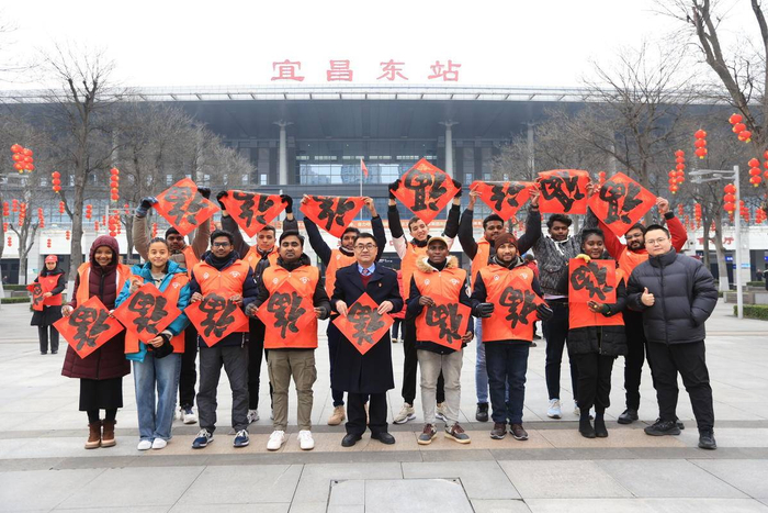 “洋雷锋”在宜昌东站广场前与车站工作人员合影留念。 （通讯员 陈龙 摄）