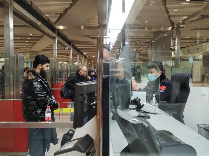 1月2日，北京边检总站移民管理警察为入境旅客办理边检手续。（北京边检总站供图）