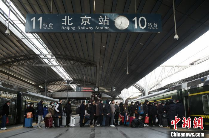 在铁路北京站，旅客有序乘坐1461次列车前往自己目的地。中新网记者 殷立勤 摄