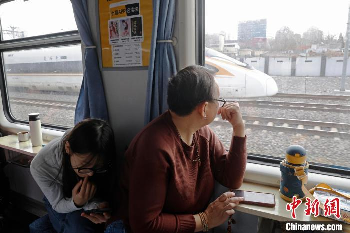 旅客乘坐1461次列车前往自己的目的地，与复兴号动车组一起行驶在双轨上。中新网记者 殷立勤 摄