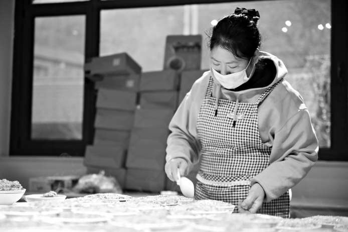 民宿餐厅中，工作人员正在分装黏饭，加急制作礼盒。本版图片 赵雨晴 摄