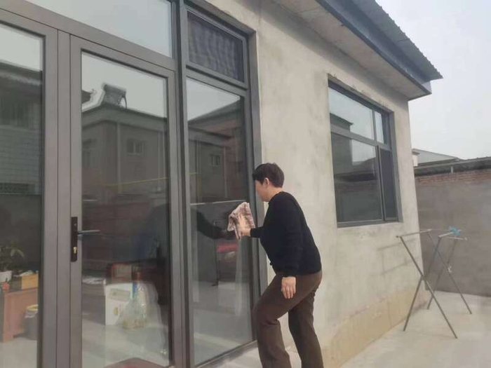 小柳村村民郑学彦正在给新房擦玻璃