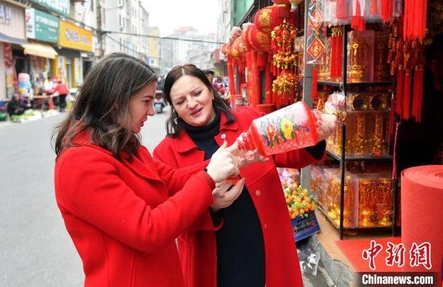1月29日，卡佳和妈妈穿着一袭红衣逛集市买年货。中新社记者 吕明 摄