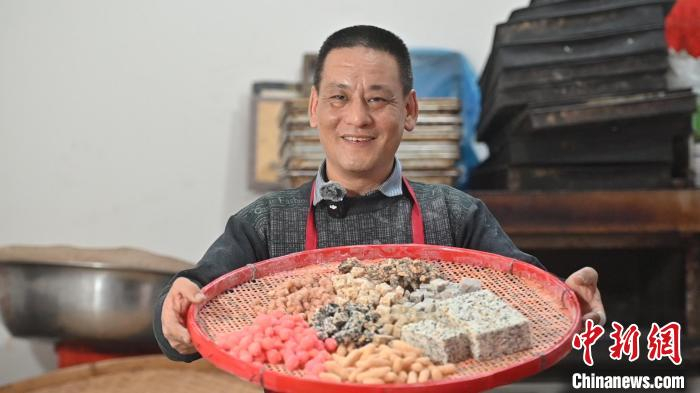 图为灶糖手工艺人卓文章展示各式各样的灶糖。 余汕康 摄