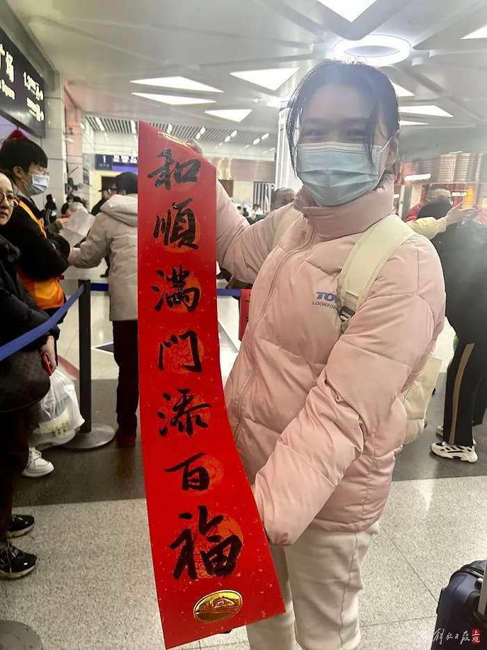 来自江苏盐城的小葛展示刚拿到的春联。施晨露摄