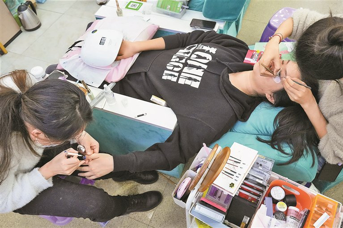 顾客同时接受美甲和美睫服务。（本文图片均由 深圳晚报记者 严文婷 实习生 文国梁 摄）