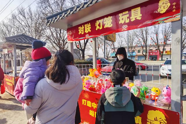 摊位前，一位家长正在给孩子选购玩具。新京报记者 曹晶瑞 摄