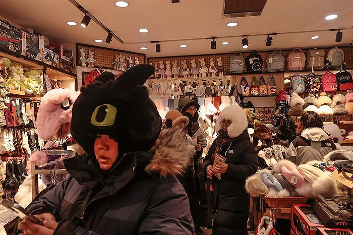 因为旅游的爆火，服装店推出各种款式的防寒用品供游客挑选。