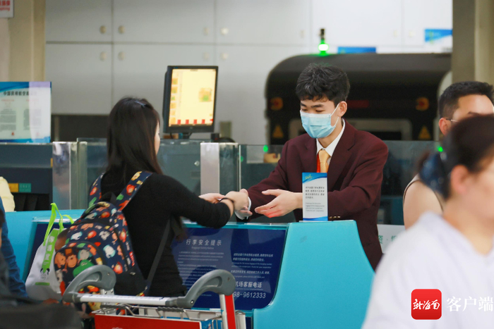 三亚凤凰机场工作人员为旅客办理值机。海南机场集团供图