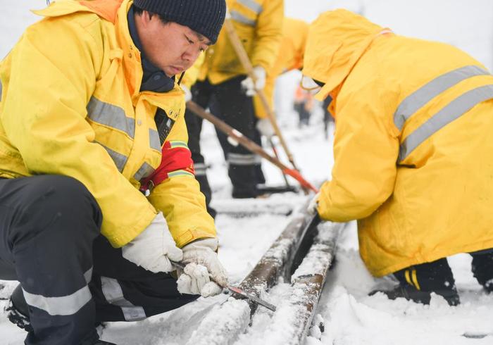   2月4日，武汉高铁工务段工人在清扫轨道上的冰雪。 新华社记者 杜子璇 摄