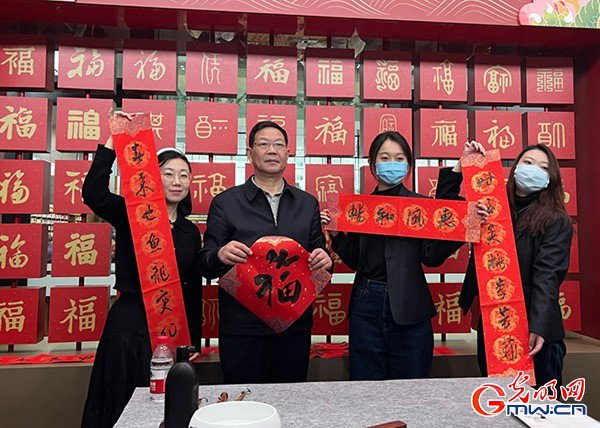 王学岭（左二）书写春联、“福”字，送上新春祝福