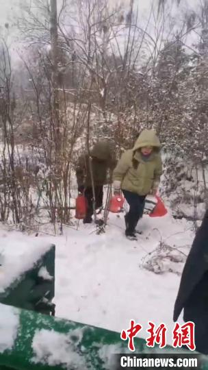 热心村民拎着热水瓶徒步从一旁小路“翻山越岭”，送至车辆滞留路段。受访者 供图