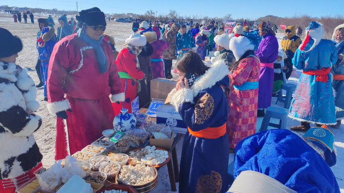 赤峰市克什克腾旗达日罕乌拉苏木第十二届银冬驼文化节奶食品展区，游客们正在品尝美食