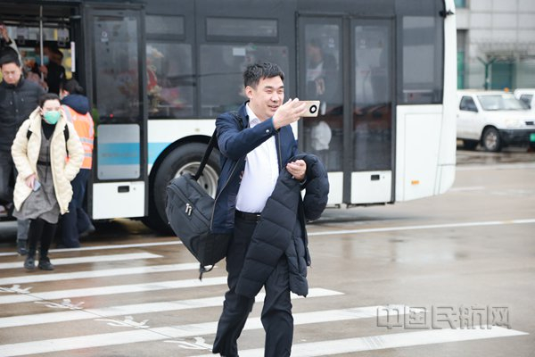 一下摆渡车就忙着为C919拍照留影的航班旅客（胡夕姮/摄）