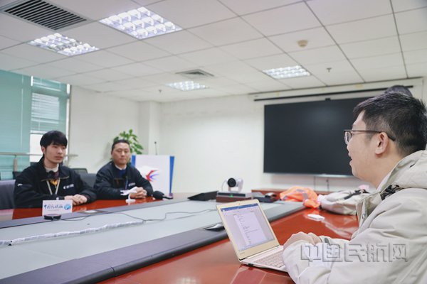 本报记者钱擘采访C919春运航班机务保障人员王海荣（左二）和傅超强（左一）（胡夕姮/摄）