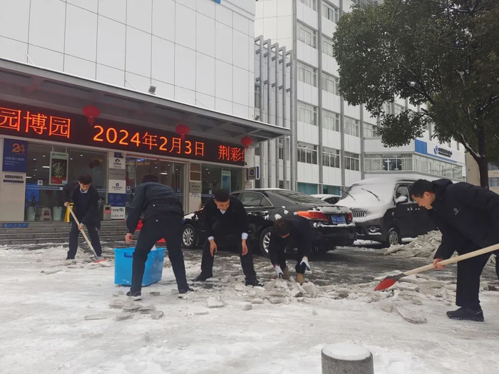 建行荆门分行营业部工作人员清理营业网点门前积雪（摄影/杜涵凝）