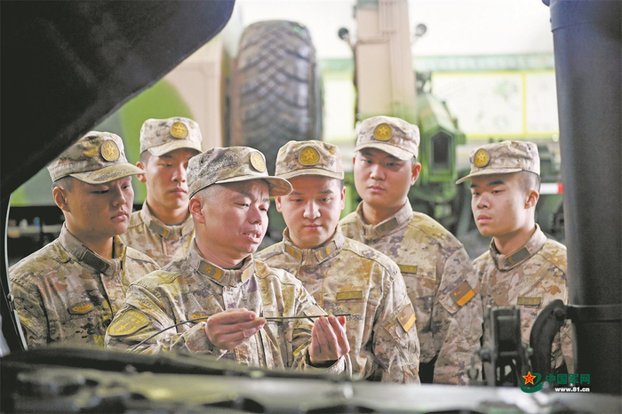 火箭军某部一级军士长张钦民(左三)为官兵讲解车辆维护保养知识.