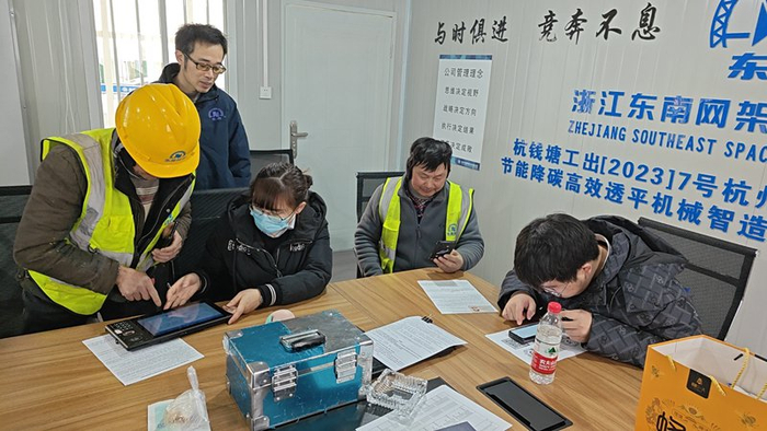 图为交通银行浙江萧山支行员工多次前往市郊工地，搭建临时办公地点，为忙碌的工人们办理银行卡，供领取工资使用。  记者 左希 摄