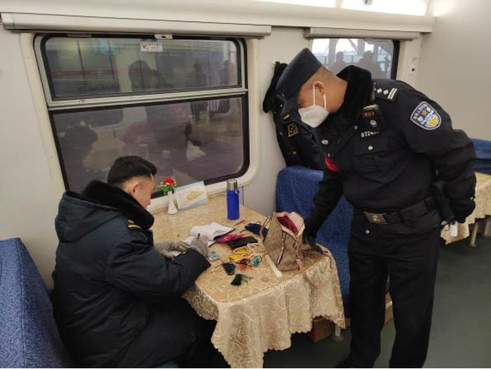 图为：列车长与乘警清点旅客遗失物品。