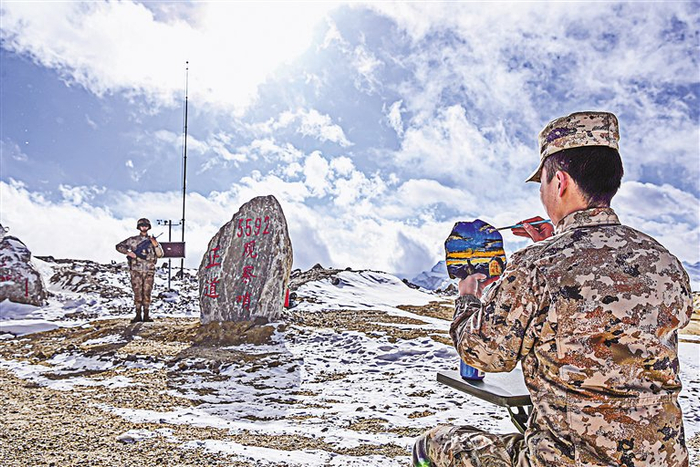 5592观察哨的一位战士在石头上作画。刘煜钦　摄