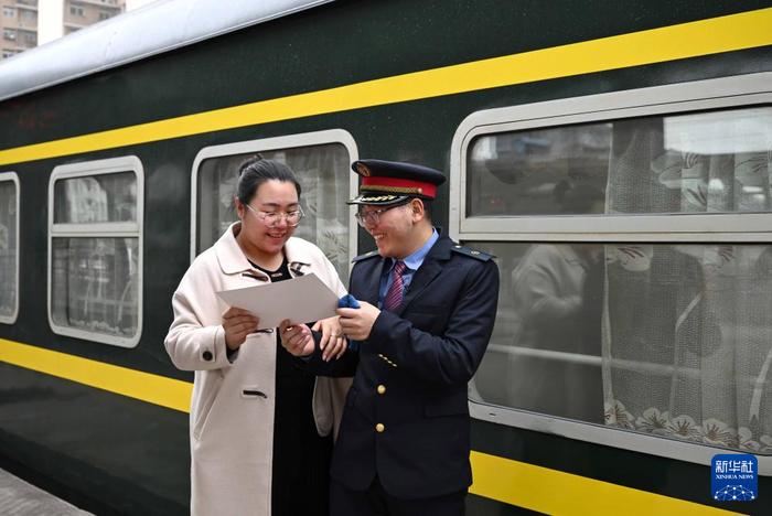 　　在新乡站站台上，苏媛婷将婚书交给杜永其(2月1日摄)。新华社记者 李安 摄