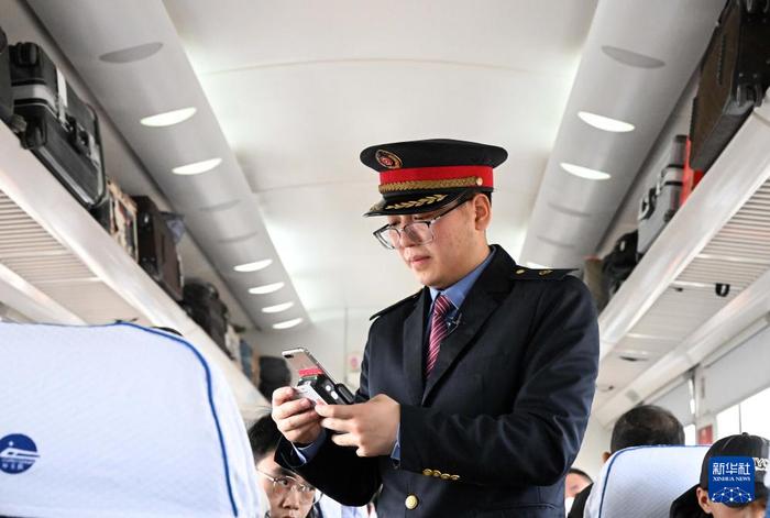 　　杜永其在K4081次列车车厢中为旅客验票(2月1日摄)。新华社记者 李安 摄