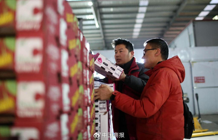 济南堤口果品批发市场，蓝可果品负责人孙守平（右）和客户在挑选智利车厘子。（图片由CNSPHOTO提供）