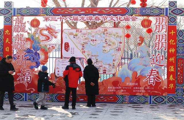 龙潭公园北门，游客观看庙会游览图。新京报记者 王贵彬 摄