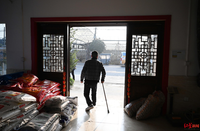 ▲张泽均杵着拐杖走出办公室