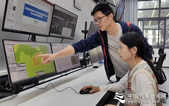 2月5日下午，海南省气象台副台长董凌宇（后）与预报员柯元慧分析琼州海峡春运期间天气形势。 图/刘原岳