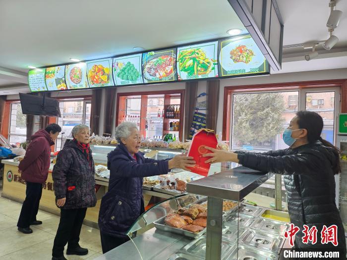 春节前夕，呼和浩特市的老年人在为老服务餐厅选购定制版年货。梁良摄