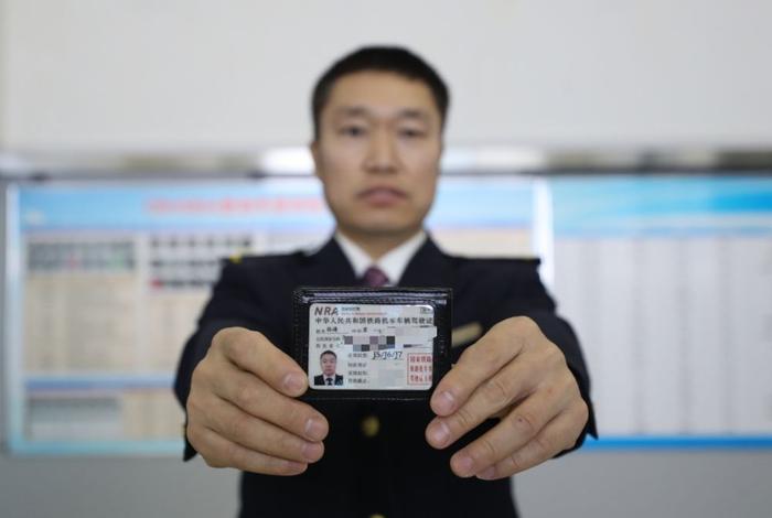 2月4日,动车组司机孙涛展示动车组司机驾驶证新华社记者 杨青 摄