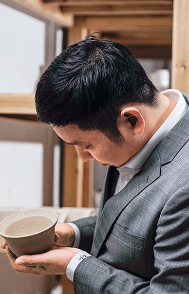 徐锦察看刚印坯成型的暗刻纹蛋壳杯   受访者供图