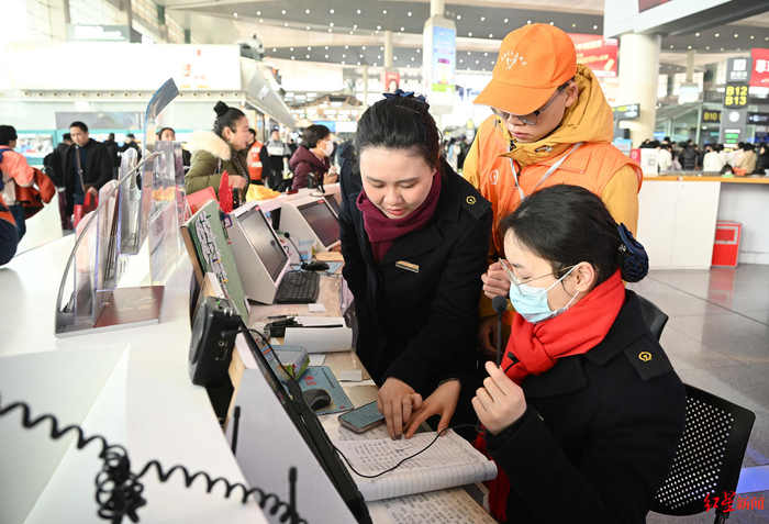 ▲杨敏（右3）正在服务台和同事核对信息