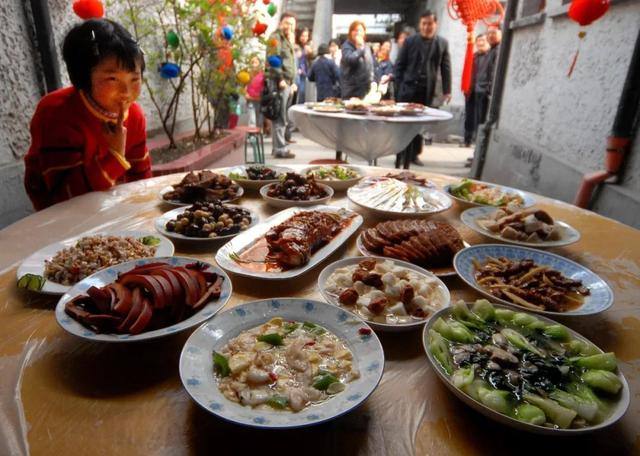 2007年春节，石库门弄堂里的年夜饭。还未开席，香味扑鼻的年夜饭已让小女孩直咽口水（图源：新民晚报 摄影：杨建正）