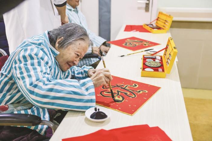 黄浦区老年护理医院节日氛围扑面而来,不少老人挥毫写福字。本报记者 袁婧摄