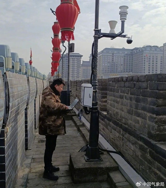 在西安城墙永宁门城楼上，技术人员正在安装自主研发的微型自动站  摄影：武智阳