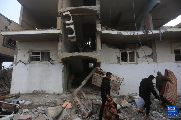   2月9日，在加沙地带南部城市拉法，人们搬运以军空袭后废墟中的物品。新华社发（哈立德·奥马尔摄）