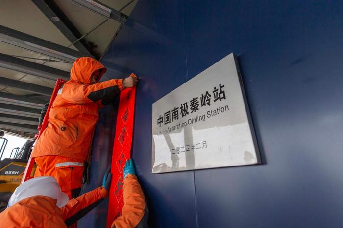   中国南极秦岭站，中国第40次南极考察队员正在贴对联。新华社记者周圆 摄