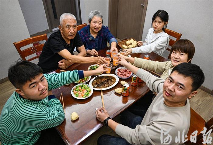 除夕夜,王瑞生(左二)一家人围坐在桌前,品尝着香喷喷的年夜饭