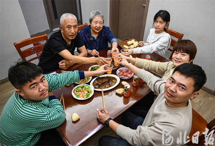 除夕夜,王瑞生(左二)一家人围坐在桌前,品尝着香喷喷的年夜饭.